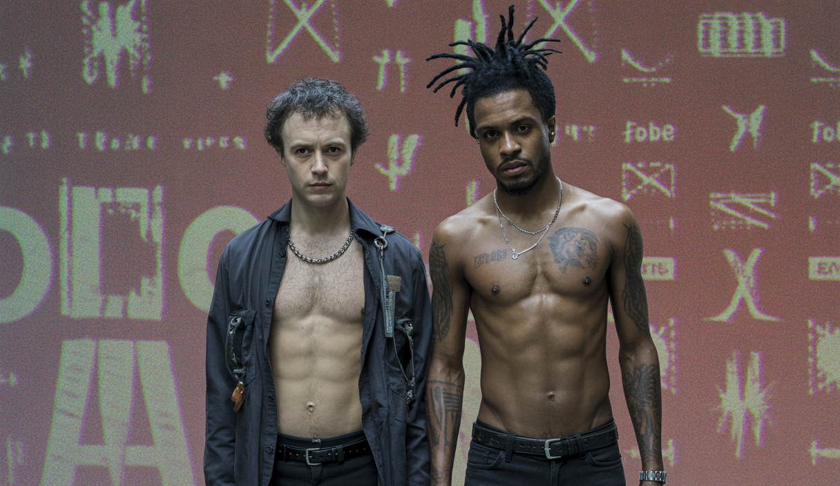 Couverture d'album de 'Tomorrow We Escape' par Ho99o9 avec des éclats de couleurs sombres et intenses mêlant punk, hardcore et hip-hop industrial